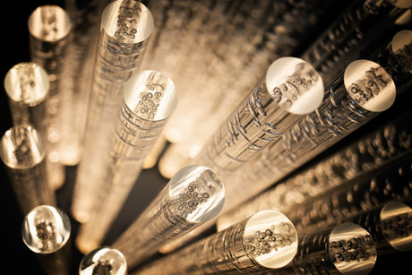Close-up of illuminated glass rods with abstract patterns.