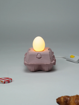 EggboxLAMP Rosé avec une lampe en forme d’œuf créant une ambiance chaleureuse dans une boîte à œufs rose