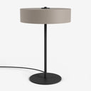 Moderne Studio Monton tafellamp met ronde beige kap en een slank zwart metalen voet