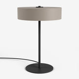 Moderne Studio Monton tafellamp met ronde beige kap en een slank zwart metalen voet