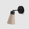 Moderne wandlamp van Studio Monton met een beige kap en zwarte wandbevestiging