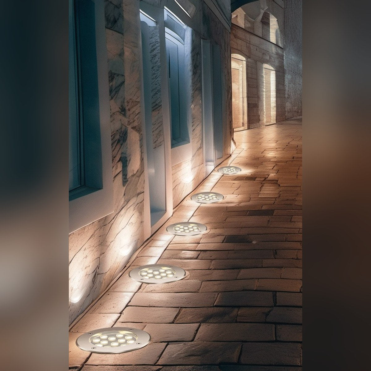 LED grondspots langs een tuinpad bij een gevel